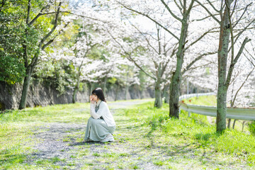 桜の花を見るショートヘアの女性