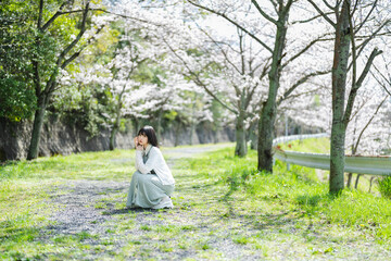 桜の花を見るショートヘアの女性