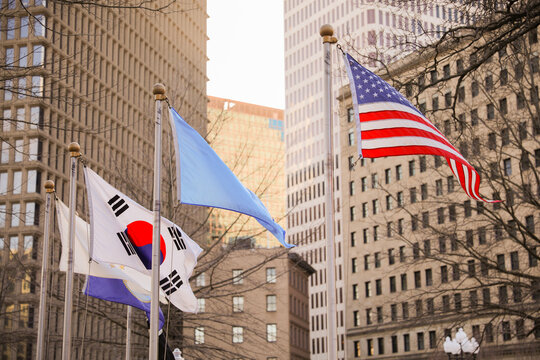 The US flag represents democracy, freedom, and patriotism. The UN flag symbolizes global cooperation and peace. The Korean flag symbolizes balance, harmony, and unity. 