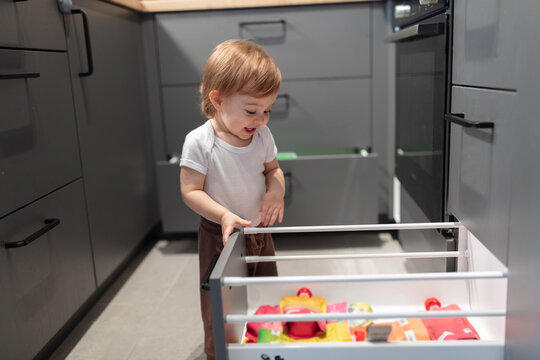 One year old child looking trough the kitchen drawer
