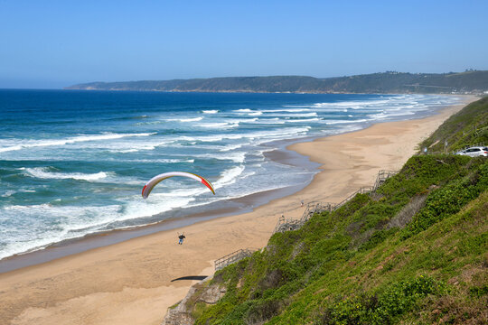 Person flying his paraglider on the beach of Wilderness, South Africa