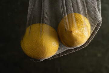 Earth day, recycling and zero waste concept. Lemons in a reusable mesh for fruits and vegetables on...