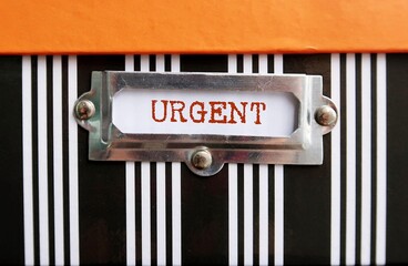 Document box with text written on tag label URGENT, concept of very important state or situation...