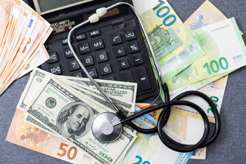 stethoscope over euro banknotes symbolize the cost of health care concept on the white background