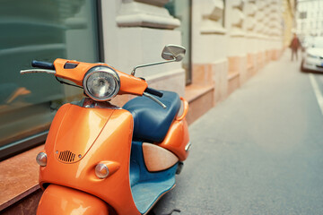 Motorbike outdoor. Orange retro style scooter on city street.