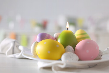 Obraz na płótnie Canvas Easter decoration with candles and colorful eggs in the kitchen interior. Easter background