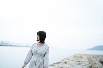 Fototapeta premium 夕暮れの海にいる女性