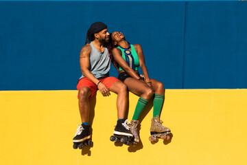 Cheerful couple with roller skating outside. Fun sexy boyfriend and girlfriend enjoy in sunny day.