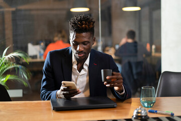 Portrait of successful businessman in office. Young smiling man using the phone.Portrait of successful businessman in office. Young smiling man using the phone.