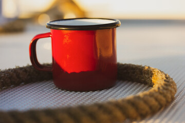 Red cup on a white yacht, ship, boat deck. Concept of tea coffee drinking while traveling at sea...