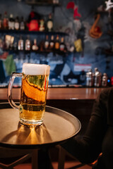 waiter hand and tray with Beer into glass on bar