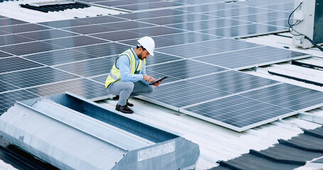 Engineer or contractor measuring solar panels on a roof of a building. Engineering technician or electrician installing alternative clean energy equipment and holding a tablet to record measurements - obrazy, fototapety, plakaty