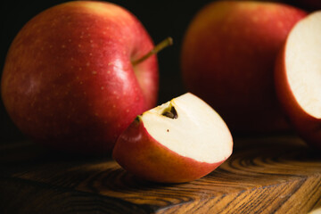 Sweet sliced apples on a wooden cutting board on a dark background, a piece of apple macro
