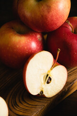 Sweet sliced apples on a wooden cutting board on a dark background, a piece of apple macro