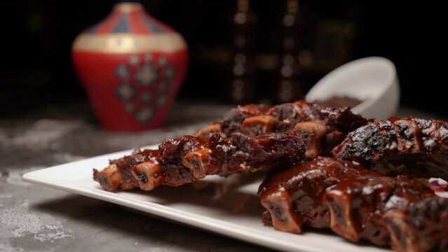 Barbecue ribs in an appetizing sauce close-up lies on a table in the dark in an expensive restaurant