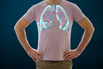 The man standing on a dark background. Picture of a human lungs. Anatomy of healthy respiratory system. Breathing exercises, inhaling. Medical concept, internal organs
