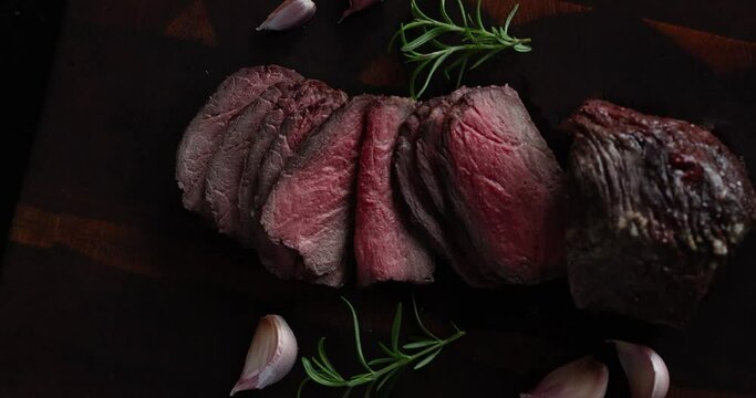 Roast beef on cutting board with salt and pepper. View from above.
