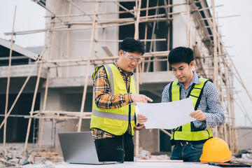 Architect team of Specialists use laptop computer on Construction Site, construction project, architectural Investor, Businessman and worker discussing blueprint plan