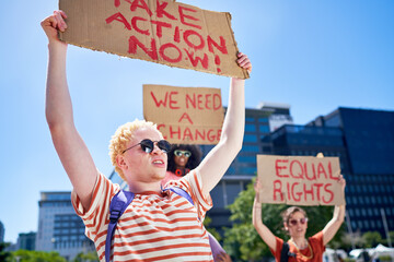 Young protesters holding equal rights signs in sunny city