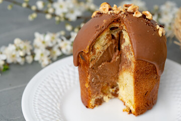 Cut Easter cake on plate decorated with spring flower branches