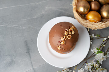 Ester cake with chocolate topping and nuts on gray background