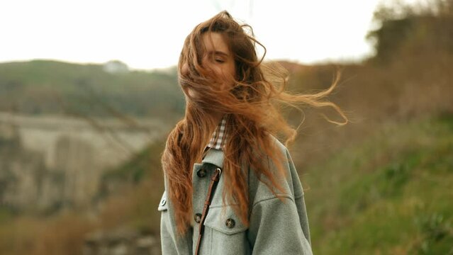 Portrait of a beautiful smiling cheerful brunette sexy smiling woman with long hair blowing strongly in the wind.