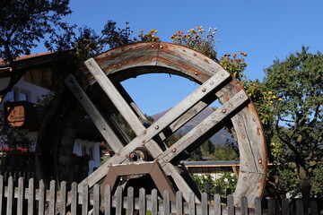 an old water wheel as decoration with flowers