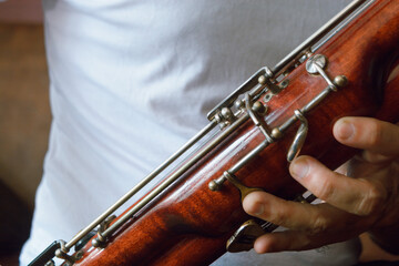 Fototapeta premium close-up of male hands playing the bassoon, copy space