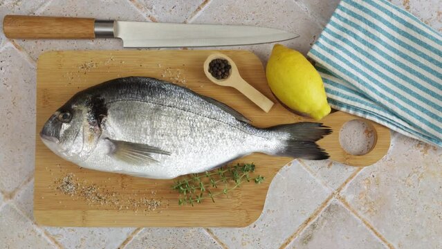 daurade enti&egrave;re, en gros plan, sur une table de cuisine