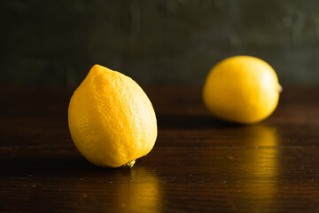 Yellow juicy lemons on a dark wooden background