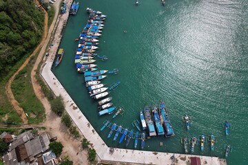 blue and white fishing boat anchored in a harbor. aerial photography of the harbor. Indonesia is a...