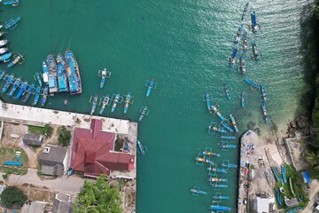 Fototapeta na wymiar blue and white fishing boat anchored in a harbor. aerial photography of the harbor. Indonesia is a maritime country and the largest fish producer in the world. Indonesian harbour. pantai Sadeng