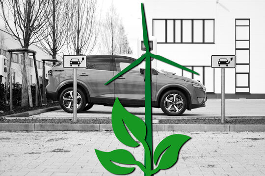 green wind turbine and green electricity from wind power for electromobility, green plant in the foreground graphic on the black and white photo for green electricity and natural electricity