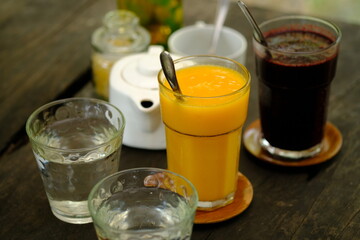 refreshing cold drinks. Mango juice, mulberry juice, water on a brown wooden table. refreshment drink. jus buah. assortment of juice. 