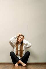beautiful young woman with long hair sitting on the floor