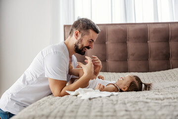 A happy father is preparing to change daughter's diaper.