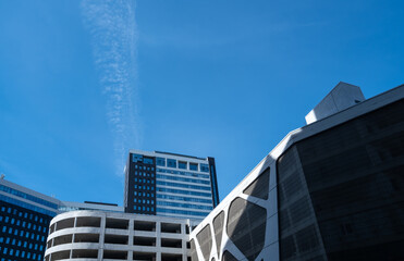 Tall buildings made of glass and concrete against the sky.