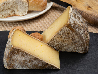 Fototapeta premium Pieces of cheese tomme de montagne or tomme de savoie made from cow milk in French Alps close up