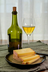 Wine and cheese pairing, local Comte cheese produced in the Franche-Comte region and special and characteristic yellow wine vin jaune from Jura region, France