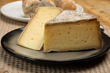 Pieces of cheese tomme de montagne or tomme de savoie made from cow milk in French Alps close up