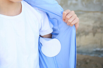 The teenager shows a strip of sweat attached to the armpits of shirt.
