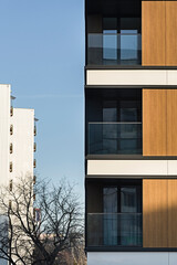 Detal na nowoczesny budynek wielorodzinny w centrum miasta. Duża ilość kondygnacji. Balkony i loggie. Słoneczna pogoda - obrazy, fototapety, plakaty