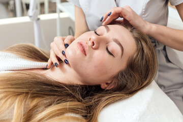 Fototapeta premium Beautician performs an analysis of the patient's facial skin
