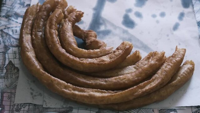 holding some churros with his hand, typical Spanish food