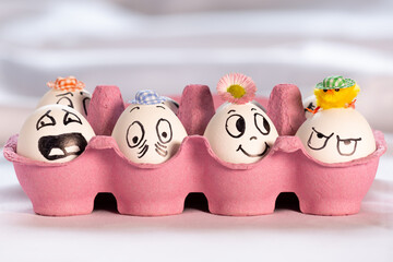 lustige Ostereier mit Gesichtern, in pinkem Eierkarton