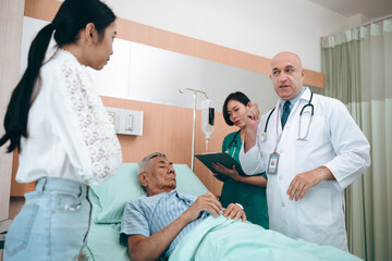 professional doctor standing by explain the treatment information via male elderly patient lying in bed in private hospital sickroom. The treatment program is suitable for people to socialize elderly