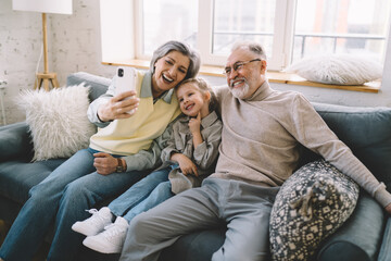 Happy family taking selfie in living room at home