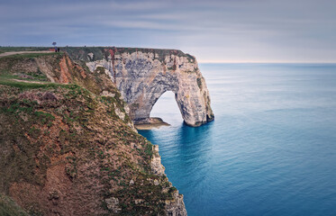 Fototapeta na wymiar Sightseeing view to the Porte d'Aval natural arch cliff washed by Atlantic ocean waters at Etretat, Normandy, France. Beautiful coastline scenery with famous Falaise d'Aval