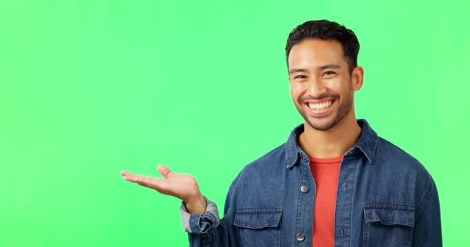 Face, pointing and man in a studio with green screen for advertising, marketing or product placement. Happy, smile and portrait of an Indian male model showing mockup space by a chroma key background