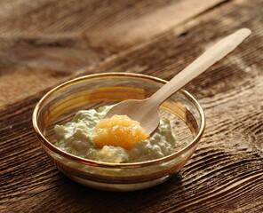 Easy and powerful facial mask from yogurt and honey for perfect skin. Edible ingredients for facial mask on the brown wooden board, natural light.